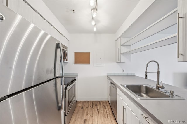 2727 Folsom St Unit 303, Boulder, CO 80304 - kitchen with appliances with stainless steel finishes, a sink, open shelves, light wood finished floors, and baseboards