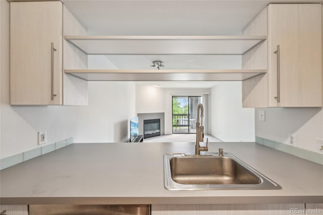 2727 Folsom St Unit 303, Boulder, CO 80304 - kitchen featuring open shelves, a sink, a glass covered fireplace, light brown cabinets, and open floor plan