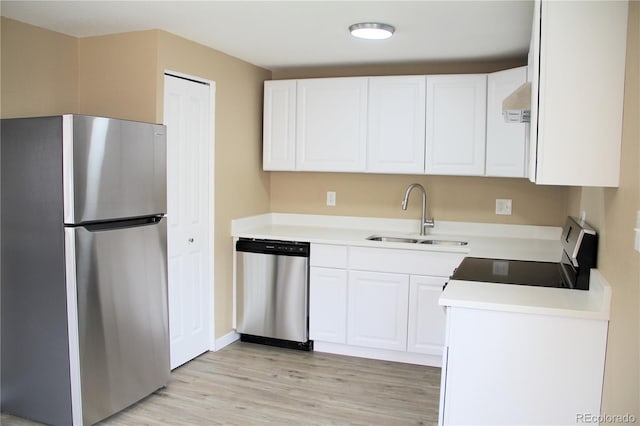 875 S Quebec St Unit 25, Denver, CO 80247 - kitchen with appliances with stainless steel finishes, a sink, light wood-style flooring, white cabinets, and light countertops