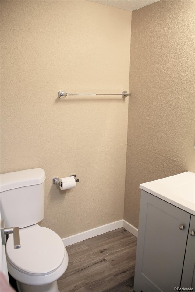 875 S Quebec St Unit 25, Denver, CO 80247 - half bath featuring wood finished floors, vanity, toilet, and baseboards