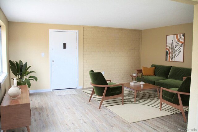 875 S Quebec St Unit 25, Denver, CO 80247 - living room featuring wood finished floors, brick wall, and baseboards
