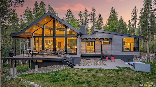 55 Blue Flag Dr, Breckenridge, CO 80424 - back of house at dusk with a deck, a lawn, and view of scattered trees