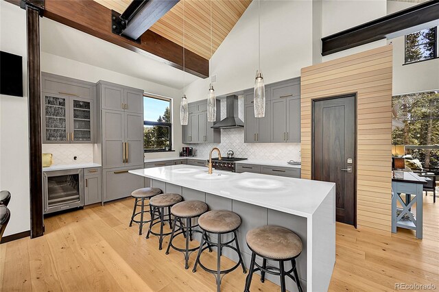 55 Blue Flag Dr, Breckenridge, CO 80424 - kitchen featuring wall chimney exhaust hood, gray cabinets, wine cooler, light wood-style floors, and wood ceiling