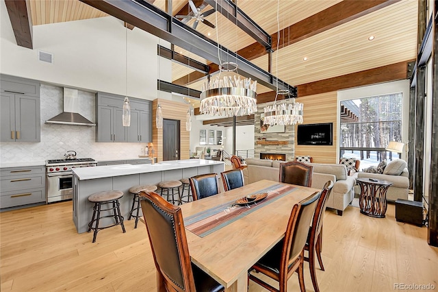 55 Blue Flag Dr, Breckenridge, CO 80424 - dining space with beamed ceiling, light wood finished floors, ceiling fan, a stone fireplace, and a towering ceiling
