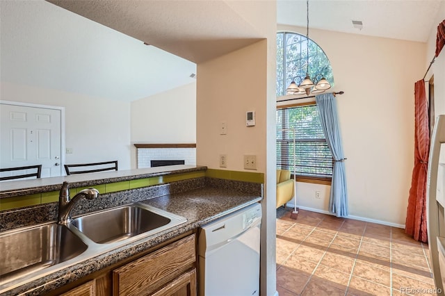 kitchen featuring dishwasher, a wealth of natural light, a brick fireplace, and hanging light fixtures