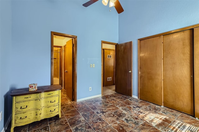 unfurnished bedroom featuring a high ceiling, a closet, and ceiling fan