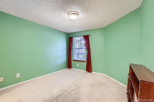 carpeted empty room with a textured ceiling