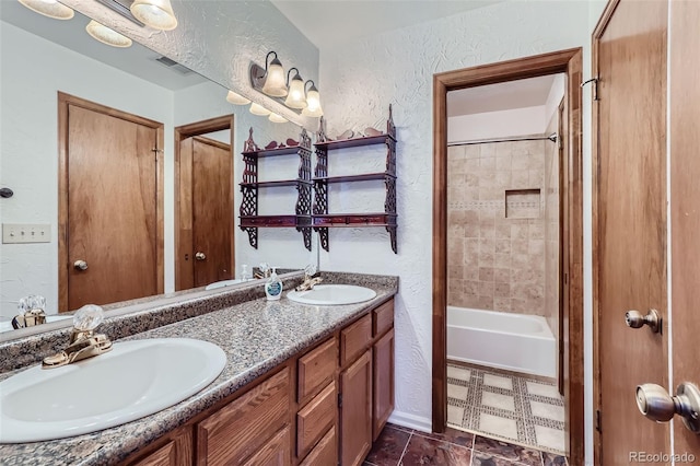 bathroom with vanity, tiled shower / bath, and tile patterned floors