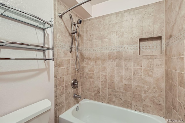 bathroom featuring toilet and tiled shower / bath combo