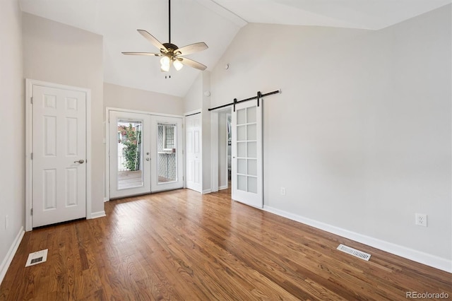 1100 S Garfield St, Denver, CO 80210 - unfurnished bedroom featuring access to outside, wood finished floors, a barn door, french doors, and high vaulted ceiling