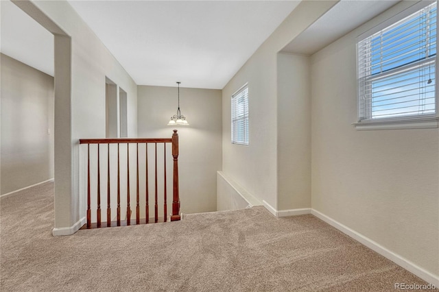 interior space featuring a healthy amount of sunlight, carpet, baseboards, and an upstairs landing