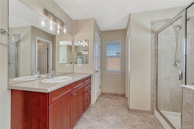 bathroom featuring tile patterned floors, a shower stall, baseboards, and vanity