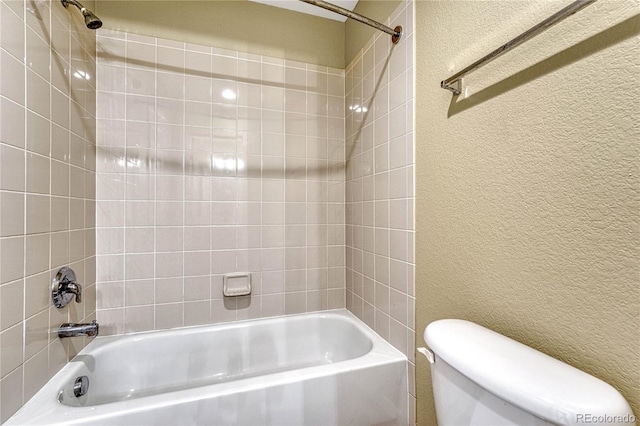 full bathroom with a textured wall, bathing tub / shower combination, and toilet