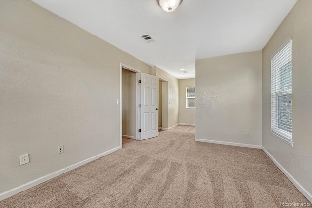 unfurnished room featuring carpet floors, a healthy amount of sunlight, and baseboards