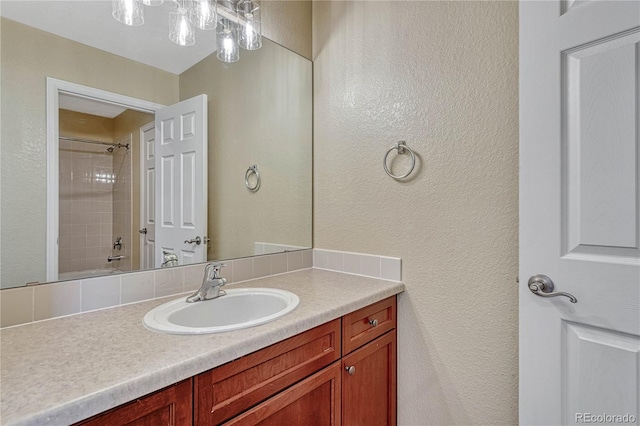 bathroom featuring a textured wall and vanity