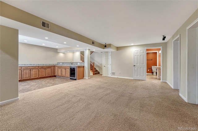 unfurnished living room with visible vents, light colored carpet, stairs, a bar, and recessed lighting