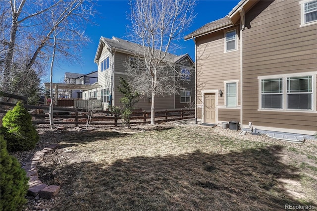 back of house with a lawn and fence