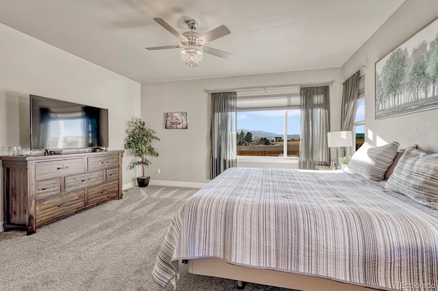 bedroom featuring a textured ceiling, light colored carpet, and ceiling fan