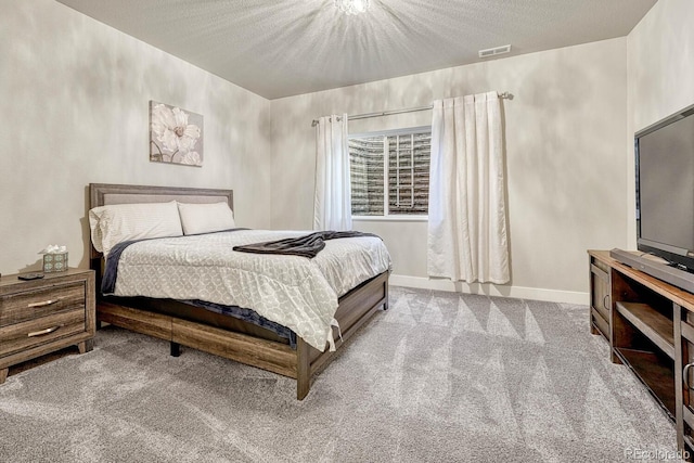 bedroom with light carpet and a textured ceiling