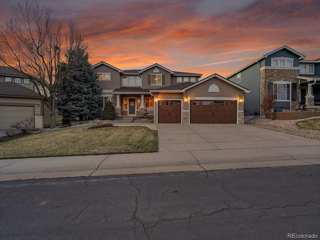 view of front of property with stone siding, driveway, an attached garage, and a front lawn