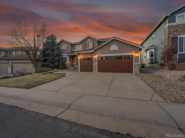 view of front facade with a garage, stone siding, and driveway