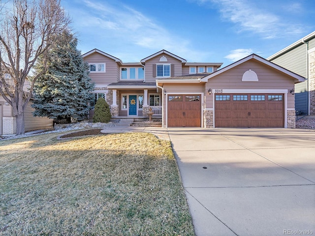 craftsman inspired home featuring driveway, stone siding, covered porch, an attached garage, and a front yard