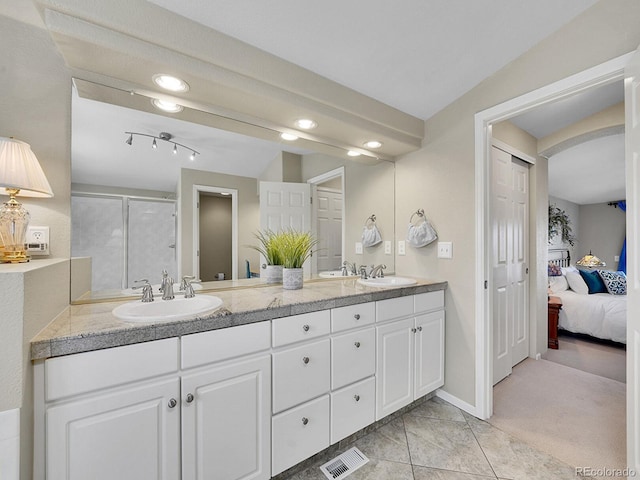 ensuite bathroom with a sink, visible vents, a stall shower, and double vanity