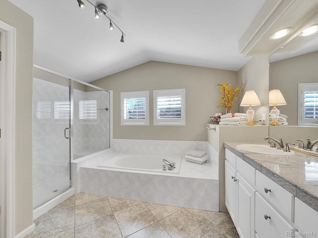 full bathroom featuring vanity, vaulted ceiling, a bath, and a stall shower