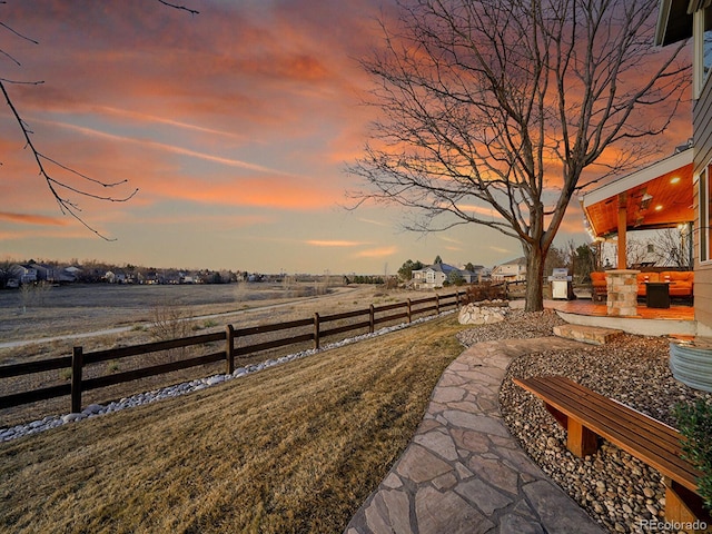 view of yard featuring a patio area, a rural view, and fence