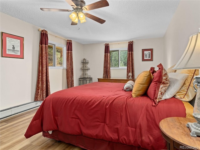1141 Koral Ct, Estes Park, CO 80517 - bedroom with wood finished floors, a textured ceiling, baseboard heating, and ceiling fan