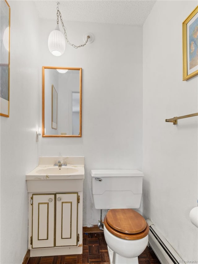 1141 Koral Ct, Estes Park, CO 80517 - bathroom with a baseboard radiator, toilet, vanity, and a textured ceiling
