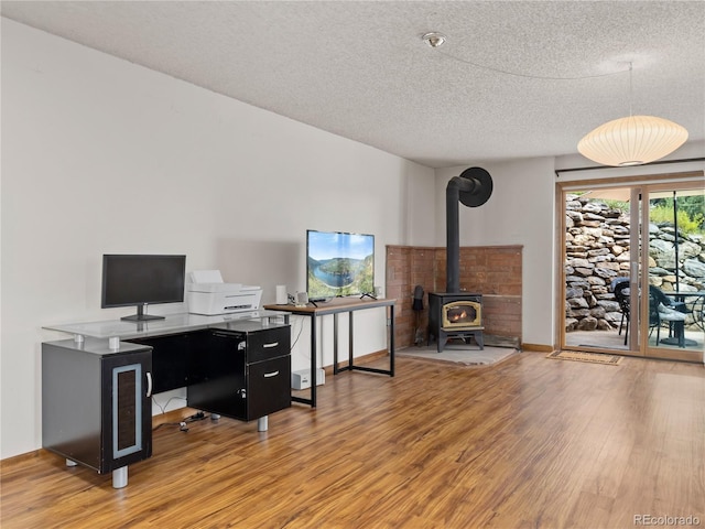 1141 Koral Ct, Estes Park, CO 80517 - office with light wood finished floors, a textured ceiling, and a wood stove