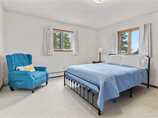 1141 Koral Ct, Estes Park, CO 80517 - bedroom featuring multiple windows, baseboard heating, carpet floors, a baseboard heating unit, and a textured ceiling