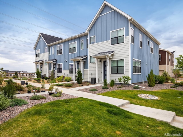 view of front of house with a front yard and central air condition unit