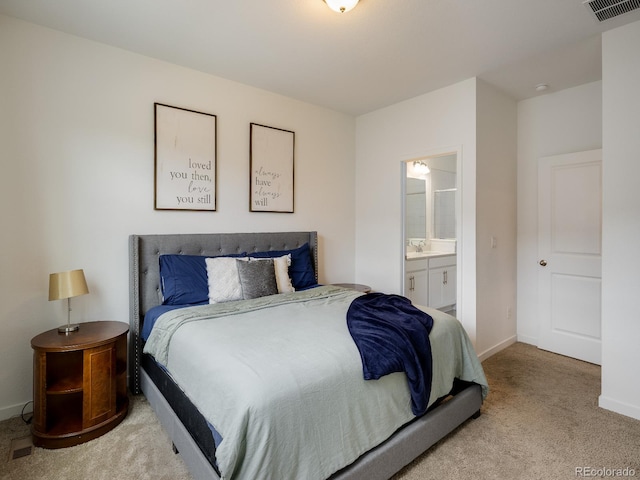 carpeted bedroom featuring sink and connected bathroom