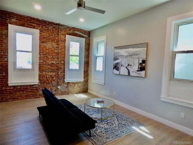 sitting room with baseboards, ceiling fan, wood finished floors, and a wealth of natural light