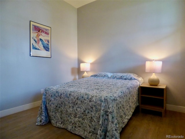 bedroom with baseboards and wood finished floors