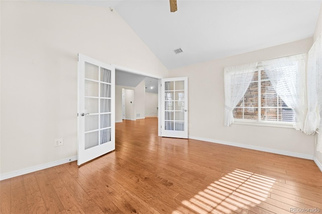 spare room featuring french doors, wood-type flooring, and high vaulted ceiling