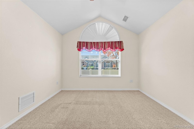 carpeted spare room with lofted ceiling