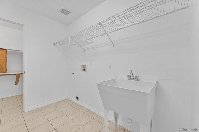 laundry area with sink, light tile patterned floors, washer hookup, and hookup for an electric dryer