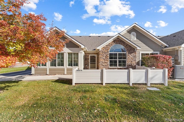 view of front of home with a front lawn and central AC