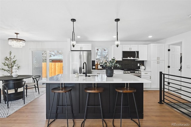 290 Beryl Way, Broomfield, CO 80020 - kitchen featuring stainless steel appliances, a sink, plenty of natural light, a breakfast bar, and recessed lighting