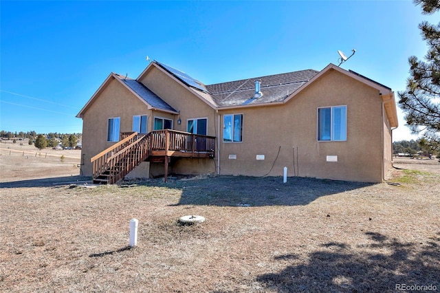 rear view of property featuring crawl space, stairway, a wooden deck, and stucco siding