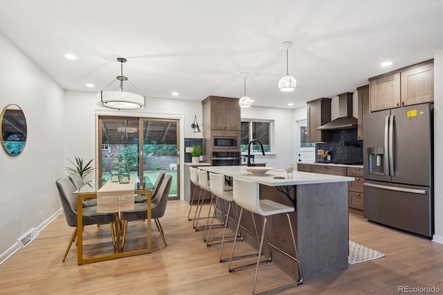 3384 W Arlington Ave, Littleton, CO 80123 - kitchen with appliances with stainless steel finishes, wall chimney range hood, decorative backsplash, light countertops, and recessed lighting