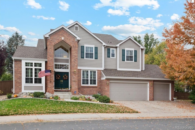 view of front of house with a front yard, concrete driveway, brick siding, and roof with shingles