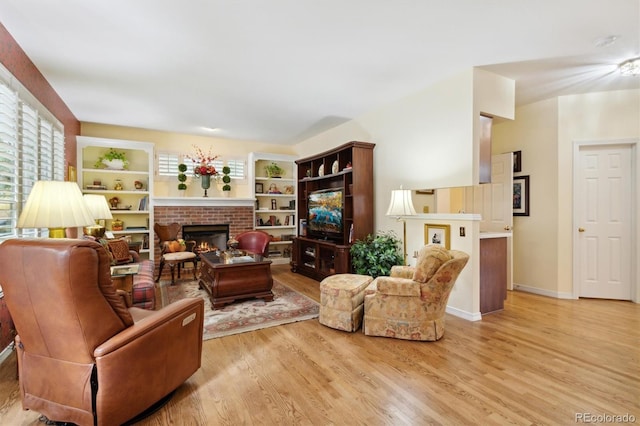 living room featuring a brick fireplace and light wood-type flooring