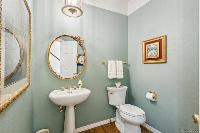 bathroom featuring toilet, ornamental molding, and hardwood / wood-style flooring