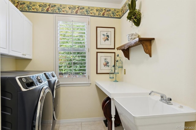 washroom with sink, light tile patterned floors, cabinets, and washer and clothes dryer