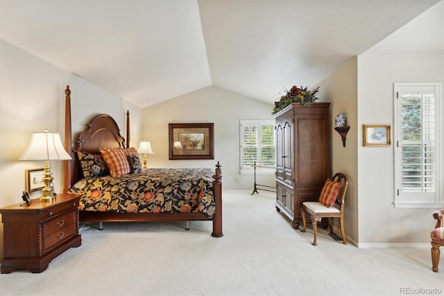 carpeted bedroom with lofted ceiling