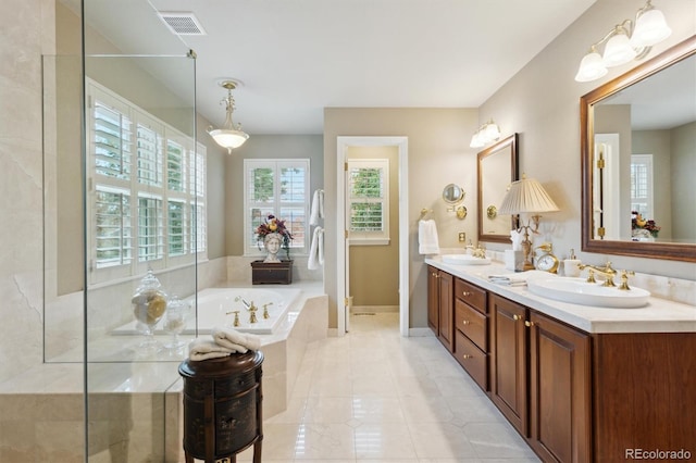 bathroom featuring vanity, tile patterned flooring, and tiled tub